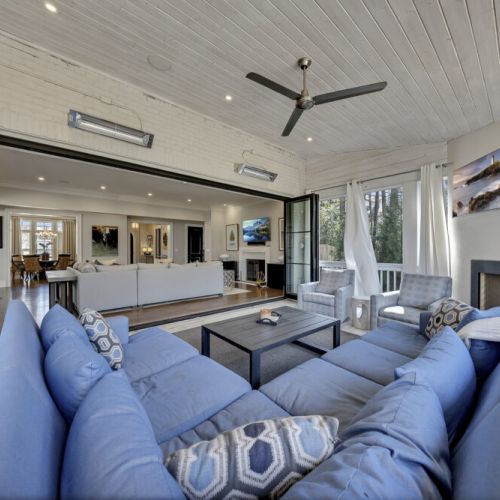 Covered outdoor living area w/ sectional seating & ceiling fan for breezy relaxation